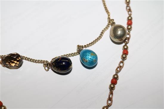 A 9ct gold necklace hung with four egg shaped charms and a 9ct gold and coral bead necklace.